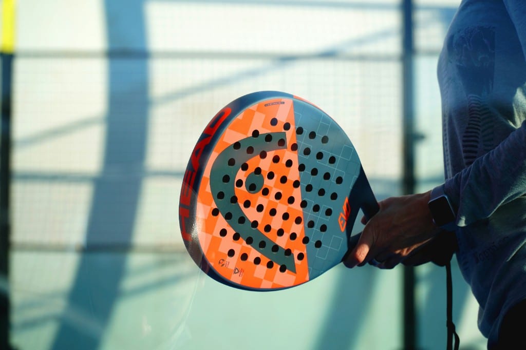Padel racket held on an outdoor padel court